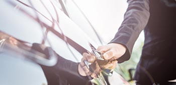 A chauffeur opening a car door